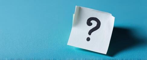 The Question Mark on a Sticky Note Against a Blue Background photo