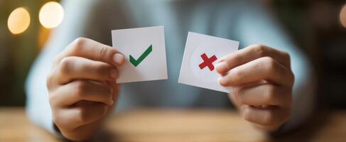The hands holding checkmark and cross symbols for decision-making process photo