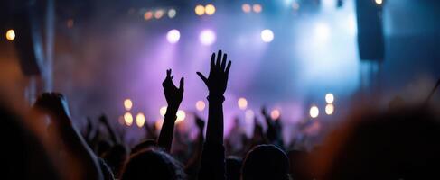 The energetic crowd at a live music concert with raised hands. photo