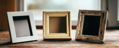 The three decorative photo frames resting on a wooden tabletop.