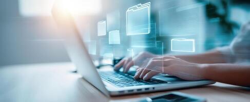 The hands of a professional typing on a laptop surrounded by digital files. photo