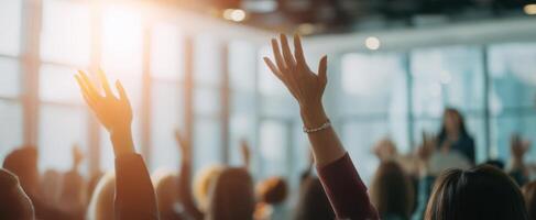 The engaged audience raising hands during an interactive seminar session. photo