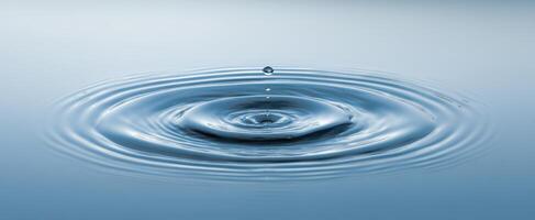 The tranquil water surface with ripples created by a single drop. photo