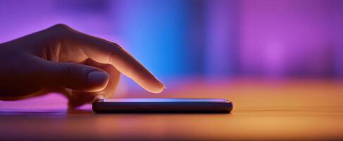 The hand gently tapping on a smartphone screen in ambient lighting. photo