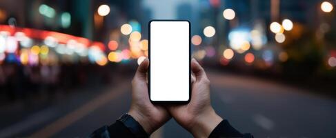 The smartphone held in hands against a blurred nighttime urban background. photo