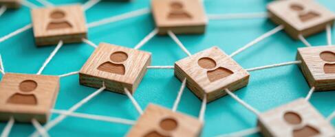 The network of connections illustrated with wooden icons representing individuals. photo