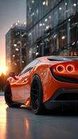 Stunning orange sports car at sunset near modern glass buildings photo