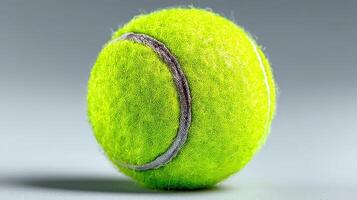 Bright green tennis ball on a smooth surface highlighting texture and design details photo