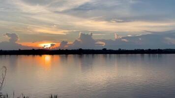 sunset over the lake, a calm lake at dawn, reflecting the soft hues of the sky on its still surface video