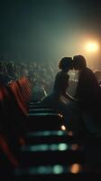 Romantic moment between a couple at a theater during a performance on a dimly lit evening photo