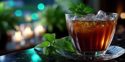 Refreshing iced tea served in a glass with mint leaves and ice during a cozy evening setting photo