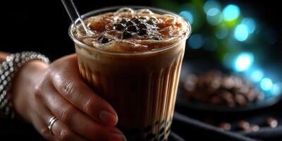 Enjoying a refreshing bubble tea with coffee flavor in a cozy cafe setting during the evening hours photo