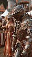 Detailed view of a knight in ornate armor alongside others during a historical reenactment in a festival setting photo