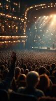 Crowds wave hands in excitement during a live concert at an entertainment venue in the evening photo