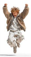 Child joyfully jumps in excited expression wearing a cozy jacket and baggy pants on a light background photo