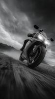 Motorcycle rider speeds through rugged terrain under dramatic clouds at dusk photo