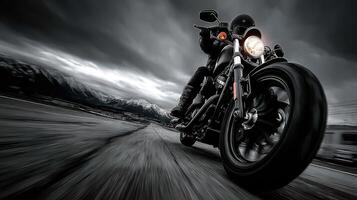 Motorcycle rider speeding on a winding road with mountains in the background under cloudy skies photo