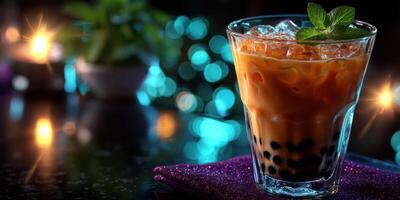 Refreshing bubble tea drink served with ice and mint leaves at a vibrant evening gathering photo