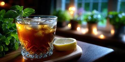 Refreshing iced tea drink with mint and lemon slice on wooden serving board in a cozy indoor setting during evening hours photo