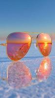 Reflective sunglasses capture stunning sunset over frozen landscape in winter photo