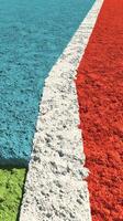 Vibrant basketball court with colorful lines and textured surface during daylight in an outdoor setting photo