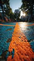Colorful basketball court at sunset showcasing vibrant markings and a hoop in an urban park setting photo