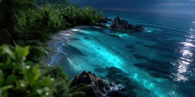 Stunning tropical beach at dusk with turquoise waters and rocky coastline photo
