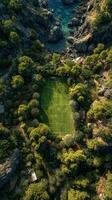 Beautiful secluded soccer field surrounded by lush greenery and rocky coastline in a serene natural setting photo