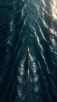 Rowers navigate through shimmering waves during sunset on an open waterway photo