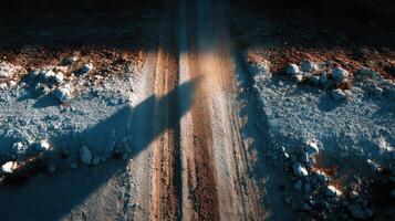 Narrow dirt path winding through rocky terrain in the early morning light under a clear sky photo