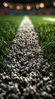 Details of a football pitch showing a close-up of a white line on the surface as grass borders the path during match preparations photo