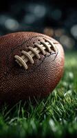 Close-up of a football resting on lush green grass in a well-lit stadium during a game photo