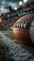 Close-up view of a football resting on the field during an evening match under dramatic stadium lights photo