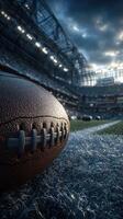Football rests on the field in a large stadium during an evening game under dramatic skies photo
