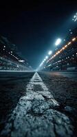 Racetrack ready for an evening event with bright lights illuminating the starting line and stands filled with spectators photo