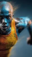 Runner in vibrant blue and orange body paint sprinting towards the camera in a dynamic and high-energy display of athleticism photo