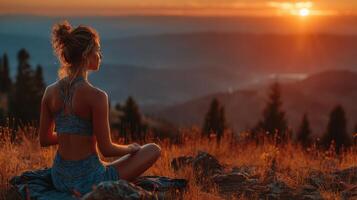 Meditation at sunset on a mountain with a serene view over valleys and distant hills photo