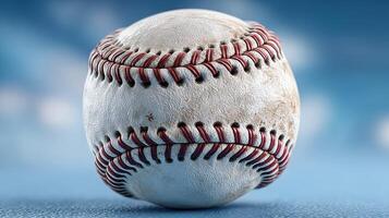 Classic baseball resting on a field with a blurred blue background during daylight hours photo