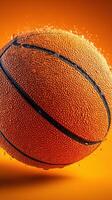 Basketball splashed with water droplets against an orange backdrop in an artistic presentation photo