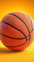 Vibrant orange basketball with droplets on a bright yellow background showcasing sporty texture and design photo