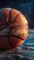 Basketball resting on a surface with water droplets reflecting light in a dimly lit environment photo