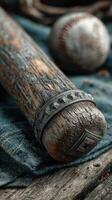Vintage baseball bat and ball resting on a dark fabric surface in a rustic setting photo