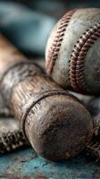 Vintage baseball equipment including a wooden bat and a worn baseball on a textured surface in soft lighting photo