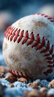 Baseball resting on frost-covered ground with reddish stitching in early morning light photo