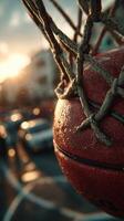 Basketball caught in the net at sunset with raindrops reflecting golden light in an urban setting photo