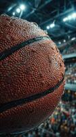 Close-up view of a wet basketball during an intense game in an indoor arena filled with passionate fans photo