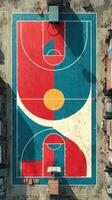 Colorful basketball court viewed from above with bright patterns and urban surroundings in midday light photo
