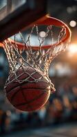 Basketball swishes through the net during a competitive practice session in an indoor gym on a sunny afternoon photo