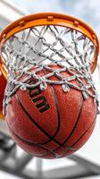 Basketball swishes through net in outdoor court during afternoon practice session photo