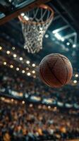 Basketball flies through the air towards the hoop in an energetic arena filled with cheering fans at a night game photo